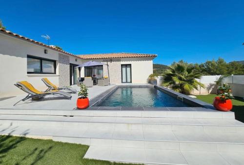 une villa avec piscine devant une maison dans l'établissement Magnifique, villa, spacieuse et lumineuse, à Rocbaron