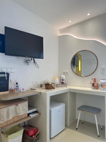 een kamer met een bureau met een tv en een kruk bij Marias Home in Kithnos