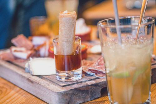 a drink on a wooden table next to a glass at Chalet Hôtel Les Airelles in Pralognan-la-Vanoise