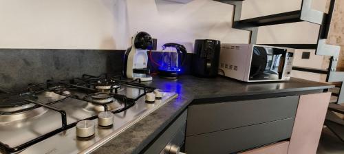 a kitchen counter with a stove and a microwave at Via Roma 106 Apartment in Sassari