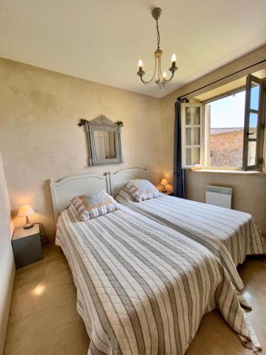 une chambre avec deux lits et une fenêtre dans l'établissement La maison de Nôtre Dame 6, à Aigaliers