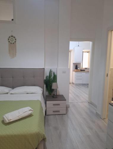 a bedroom with a bed with a green blanket and a mirror at Casa Nicolò in Mazzeo