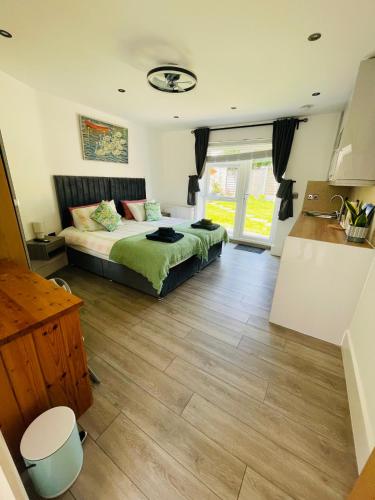 a bedroom with a bed and a wooden floor at Tudor Close NW9 8SU in London
