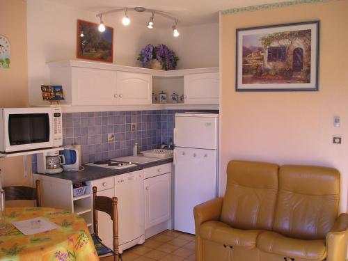 une cuisine avec un réfrigérateur blanc et une table dans l'établissement greoux eden 24, à Gréoux-les-Bains