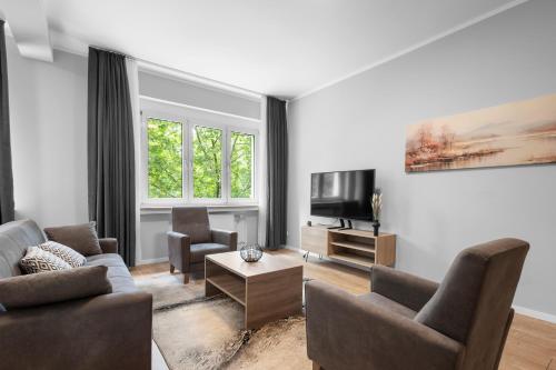 a living room with two couches and a tv at Domloge Lofts & Apartments in Cologne