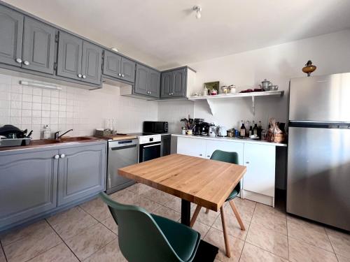 une cuisine avec une table en bois et un réfrigérateur dans l'établissement Villa Pescalune, à Lunel