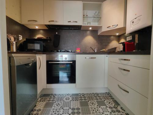 une cuisine avec des armoires blanches et un four dans l'établissement La Frégate, à Saint-Malo