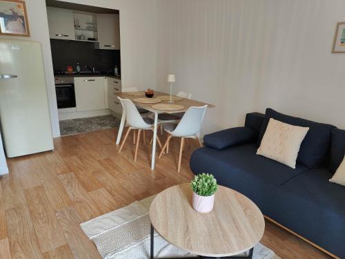 un salon avec un canapé bleu et une table dans l'établissement La Frégate, à Saint-Malo