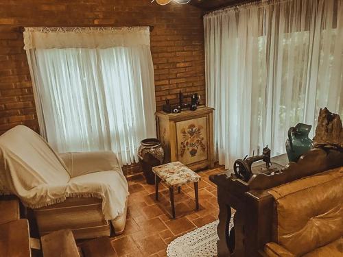 a living room with a couch and a chair at Casa de Campo Solar Das Hortênsias in Timbó