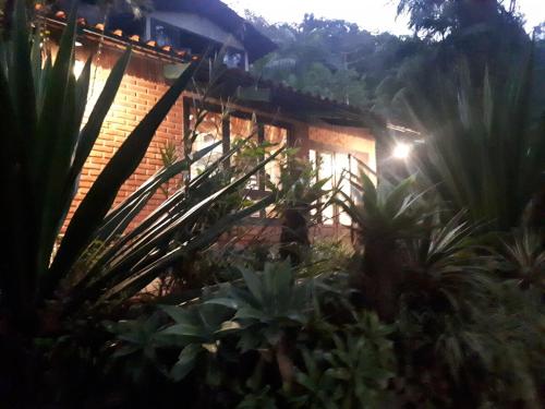 a brick building with plants in front of it at Casa de Campo Solar Das Hortênsias in Timbó