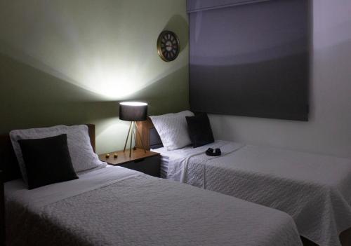 a room with two beds and a clock on the wall at Casa Bowie, Comfort y Descanso in Cuautla Morelos