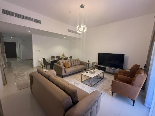 a living room with couches and a flat screen tv at 3BR Amazing Seaview Private Villa with Pool in Fujairah