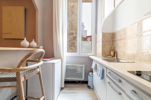 une petite cuisine avec un évier et une fenêtre dans l'établissement L'Échappée Cannoise Forville, à Cannes