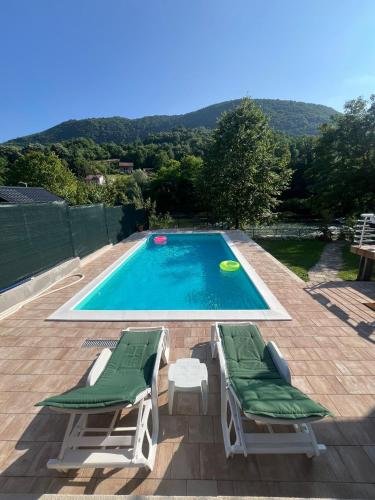 a swimming pool with two lounge chairs and a frisbee at Holiday Homer Vila na Obali Vrbasa in Banja Luka