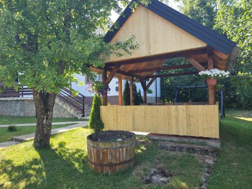 a wooden gazebo in a yard with a tree at Country house Plitvice in Plitvica selo