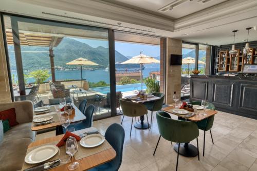 a restaurant with tables and chairs and a view of the ocean at Boutique Hotel R Palazzo in Kotor