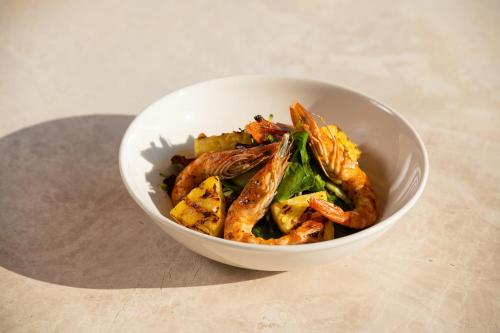 a white bowl of food with shrimp and vegetables at Porto Mykonos in Mýkonos City