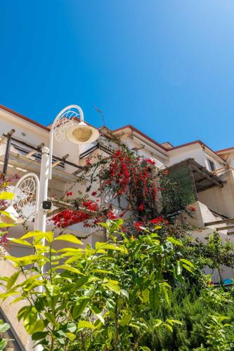 a building with red flowers on the side of it at The Bay Apartments in Sarandë