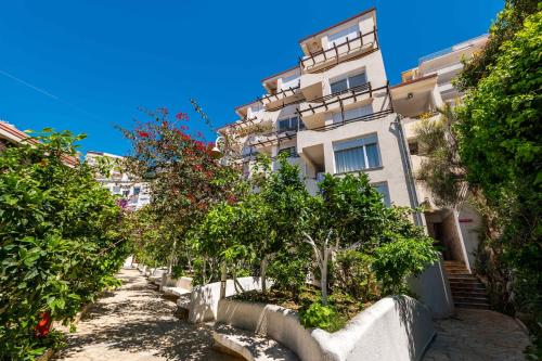 a street in front of a tall white building at The Bay Apartments in Sarandë