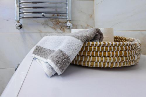 kosz z dwoma ręcznikami na blacie w łazience w obiekcie Kallikratia Suites 1 w miejscowości Nea Kallikratia