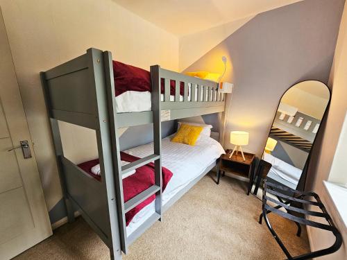 a bedroom with two bunk beds and a mirror at Group Stay with 3 Parking Spaces in Banbury