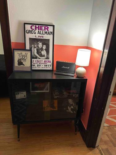 a table with a lamp and pictures on it at Friendly Songbird Suite in Berwyn
