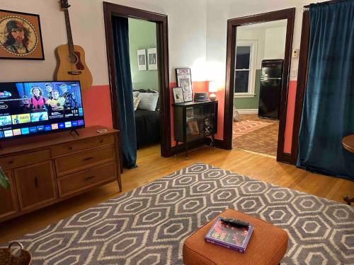 a living room with a flat screen tv on a dresser at Friendly Songbird Suite in Berwyn