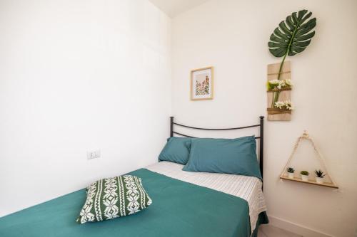 a bedroom with a bed with green sheets and a plant at Appartamento Dolce Casa 2 in  Monvalle 