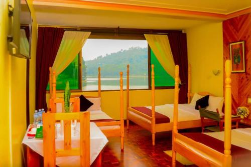 a bedroom with two beds and a large window at Bunyonyi Safaris Resort in Kabale