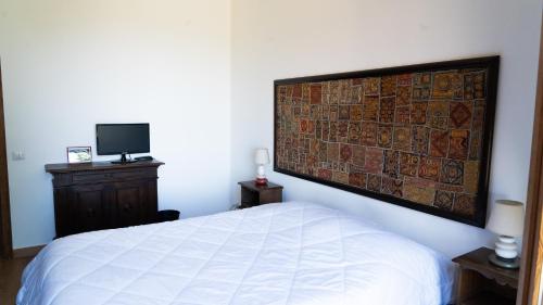 a bedroom with a white bed and a wall art at Villa Nia affittacamere in Palestrina