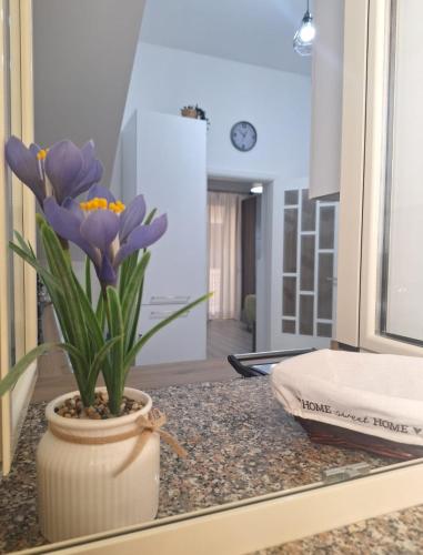 a vase with purple flowers on a counter in a room at Casa Nicolò in Mazzeo