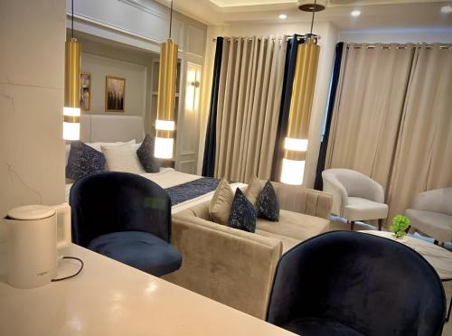 a living room with a couch and a bed and chairs at High Rise Executive Luxurious Apartments Facing Centaurus Mall - LMY Islamabad in Islamabad