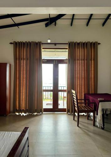 a living room with a table and a window at K Beach Resort in Kamburugamuwa