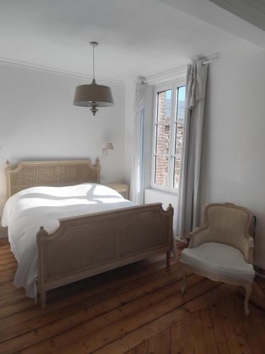 une chambre avec un lit, une chaise et une fenêtre dans l'établissement Beautiful 19th century host house near from Etretat, aux Loges