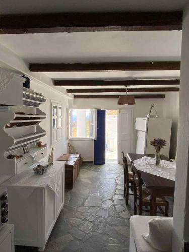 a kitchen and dining room with a table and a refrigerator at Chora's Cycladic Aura in Serifos Chora