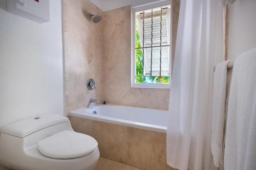 baño con aseo, bañera y ventana en Waverly House townhouse, en Saint Peter