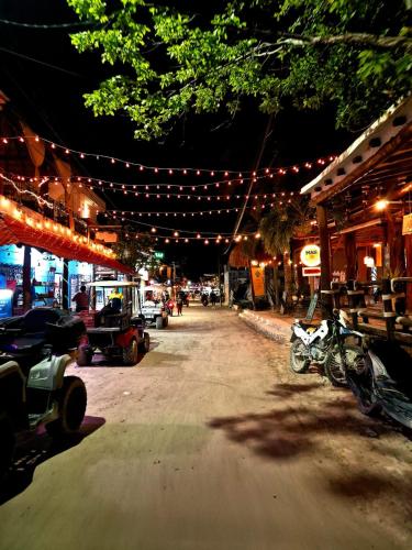 a street at night with lights and motorcycles parked at Hotel Villas Ponto Holbox in Holbox Island