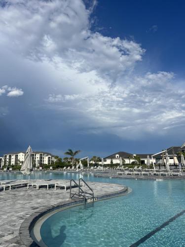 una piscina con agua azul y sillas blancas en Golf HOA Pool and many activities, en Harker