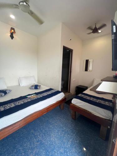 Un dormitorio con dos camas y un techo. en Vadamalai Nest near Bus Stand, en Tiruchchendūr