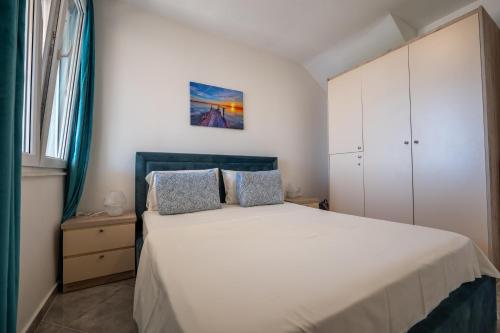 a bedroom with a white bed with two pillows at The Bay Apartments in Sarandë