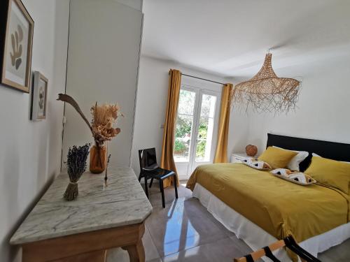 une chambre avec un lit jaune et une table dans l'établissement Maison 3 étoiles Piscine chauffée Centre Var, à Gonfaron