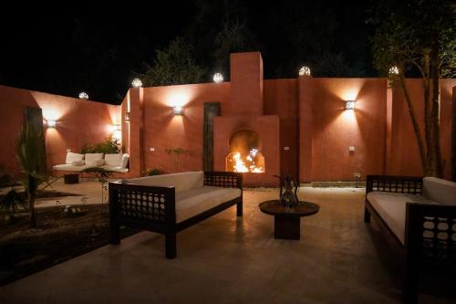 a patio with a fire place in a wall at Al Wadi Boutique Hotel in Al Aqālitah