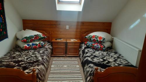 a small room with two beds and a table at Casa Boris in Bîrsana