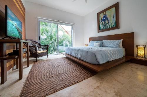 a bedroom with a bed and a large window at Penthouse Turquesa - Beachside - At Casa del Mar Condos in Playa del Carmen