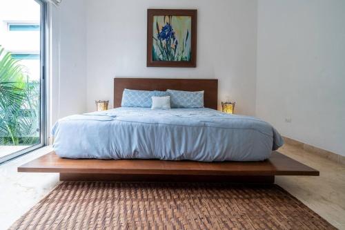 a bedroom with a large bed with a wooden frame at Penthouse Turquesa - Beachside - At Casa del Mar Condos in Playa del Carmen