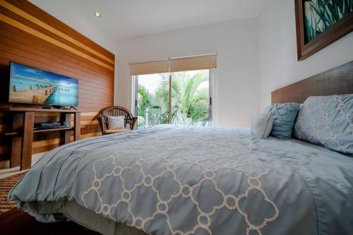 a bedroom with a large bed and a television at Penthouse Turquesa - Beachside - At Casa del Mar Condos in Playa del Carmen