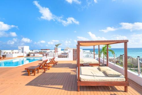 a balcony with a bed and a swimming pool at Penthouse Turquesa - Beachside - At Casa del Mar Condos in Playa del Carmen