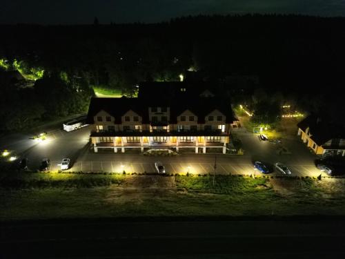 a large house lit up at night with lights at Kresovia in Giby