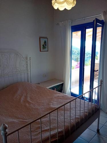 a bedroom with a bed and a sliding glass door at Villa marina in Ermioni