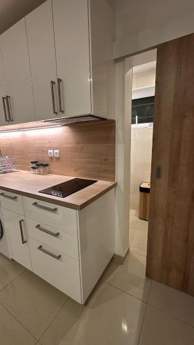 a kitchen with white cabinets and a counter top at Studio moderne et spacieux 2 in Draveil